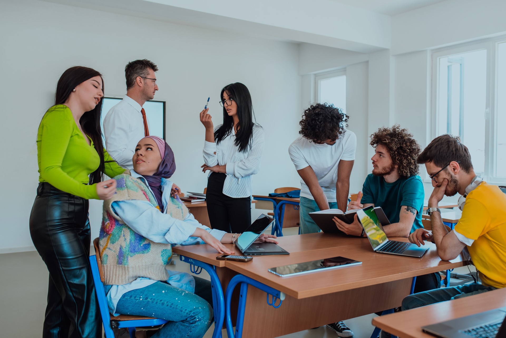 A diverse group of students gathers in a modern school classroom, passionately engaging in lively discussions about various projects, embracing teamwork and utilizing technology to enhance their learning experience